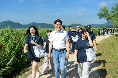 노관규 순천시장과 지역 청소년 70여 명이 순천만 어싱길을 함께 걸으며 이야기하고 있다.