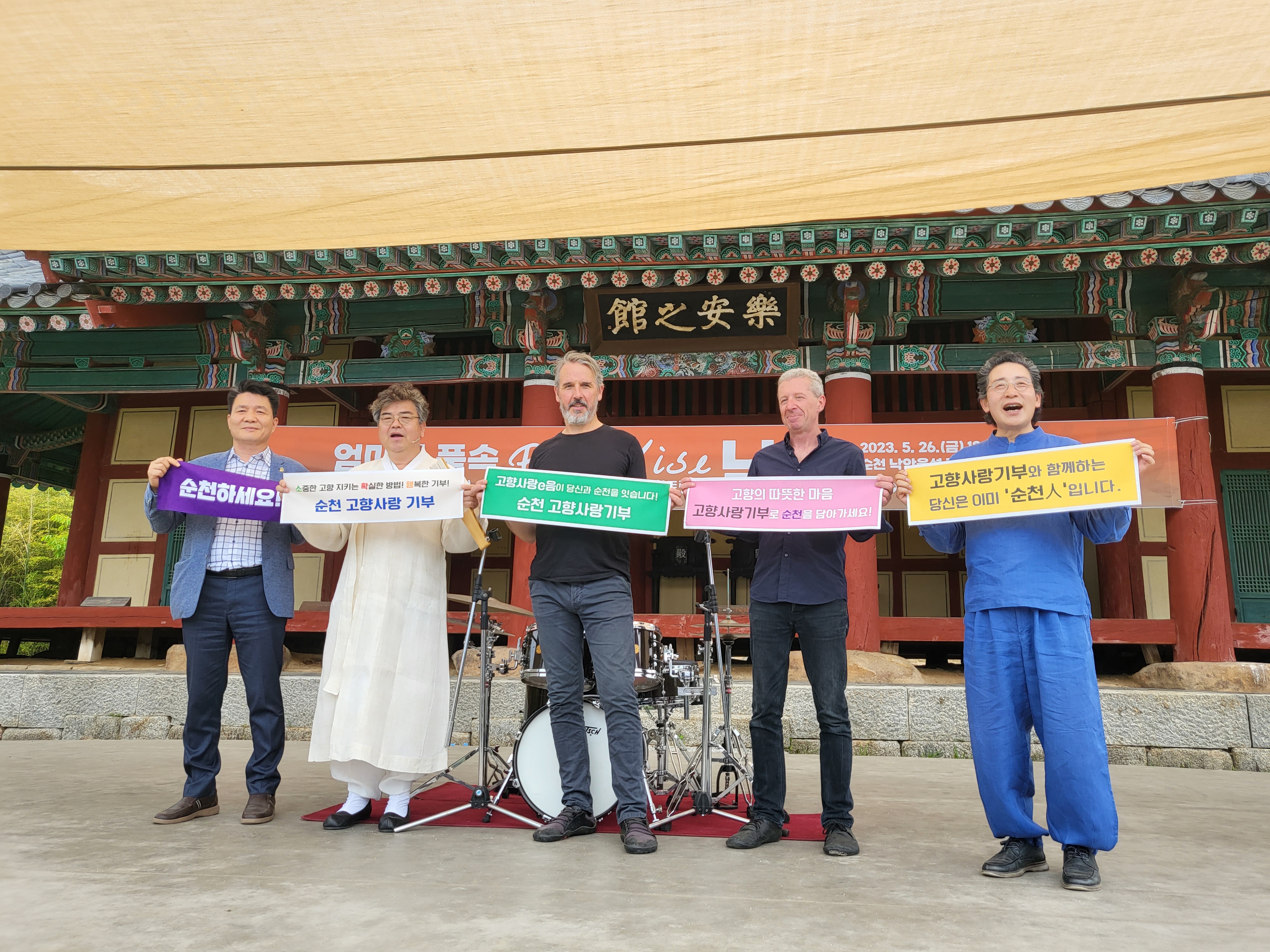 2023순천만국제정원박람회 홍보대사 배일동 명창을 중심으로 결성된 퓨전 그룹 치리(chiri)분들이 순천하세요, 순천고향사랑기부, 고향의 따뜻한 마음 고향사랑기부로 순천을 담아가세요, 고향사랑기부와 함께하는 당신은 이미 순천人 입니다. 가 적힌 현수막을 들고 있는 모습